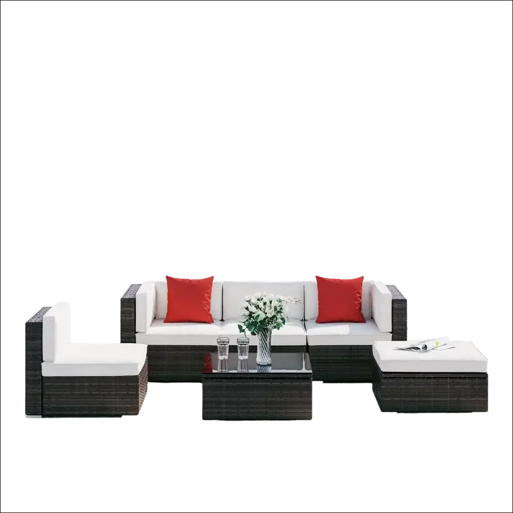 Juego de muebles de patio de mimbre marrón oscuro con cojines blancos y almohadas rojas